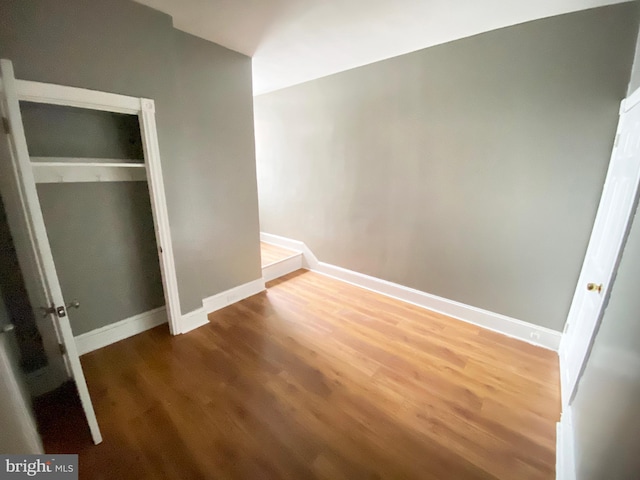 unfurnished bedroom featuring light wood-style flooring, baseboards, and a closet