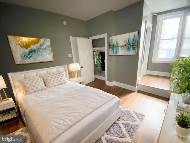 bedroom with wood finished floors and baseboards