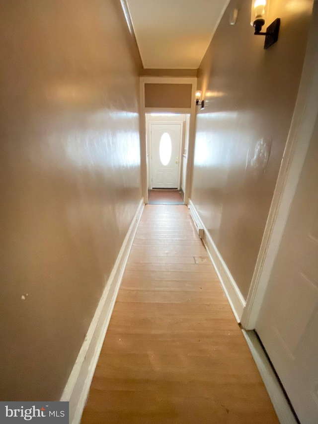 hall with light wood finished floors and baseboards