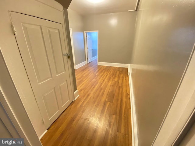 hall with light wood-style flooring and baseboards
