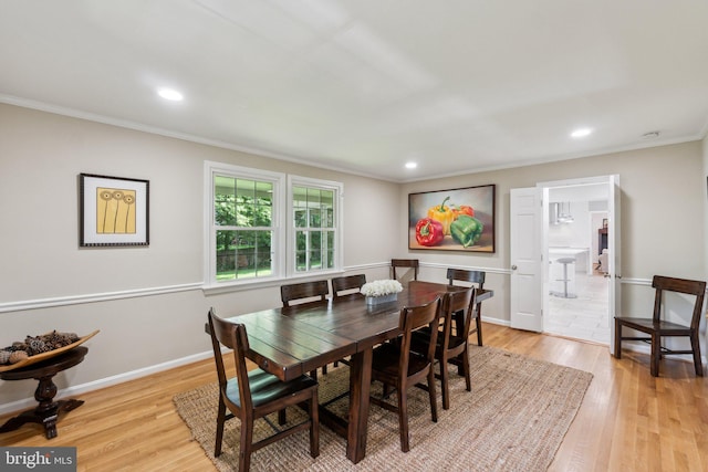 dining room featuring ornamental molding, light wood-style floors, recessed lighting, and baseboards