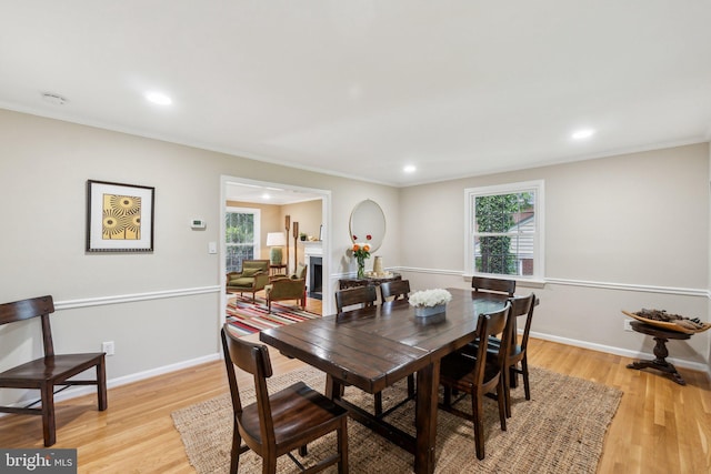 dining area featuring light wood-type flooring, recessed lighting, baseboards, and crown molding
