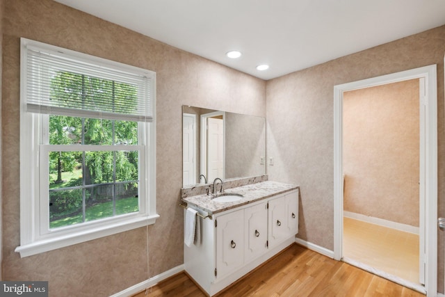 bathroom with wood finished floors, baseboards, and vanity