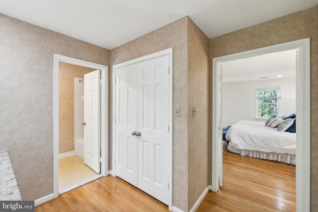 hallway with light wood finished floors and baseboards