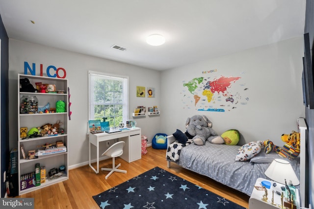 bedroom featuring wood finished floors and baseboards