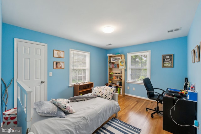 bedroom featuring wood finished floors, baseboards, and a desk