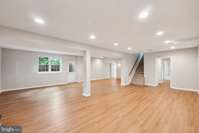 basement with stairs, baseboards, light wood-style floors, and recessed lighting