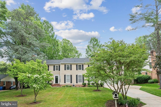 colonial home featuring driveway and a front yard