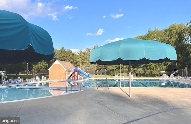 community pool with fence and a patio