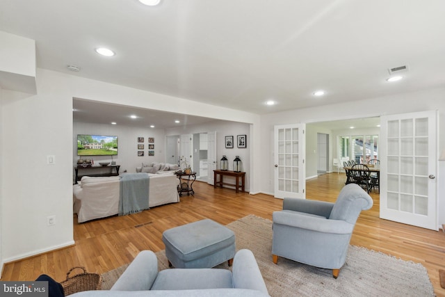 living area with french doors, light wood-style flooring, and recessed lighting