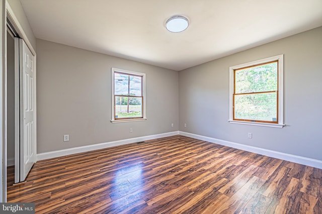50 N Ave, Cedarville, NJ 08311 - unfurnished bedroom featuring multiple windows, dark wood-style floors, and baseboards