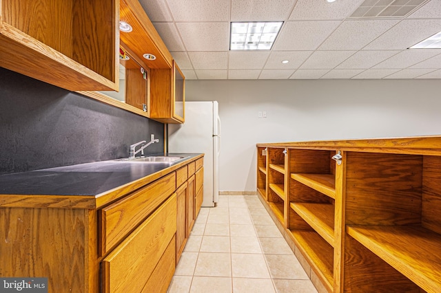 50 N Ave, Cedarville, NJ 08311 - kitchen with a sink, freestanding refrigerator, light tile patterned floors, brown cabinets, and baseboards