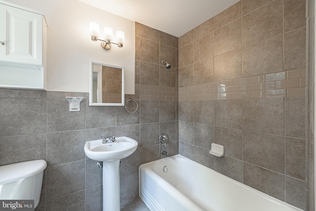full bathroom featuring toilet, tile walls, and bathtub / shower combination