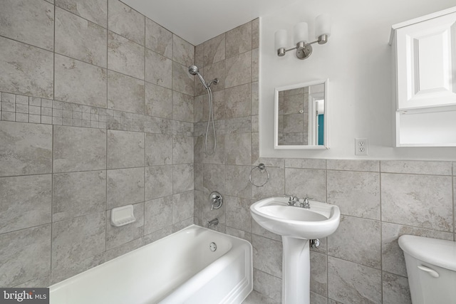 bathroom featuring toilet, tile walls, and tub / shower combination