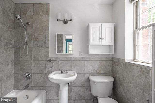 bathroom featuring plenty of natural light, tile walls, toilet, shower / tub combination, and a wainscoted wall