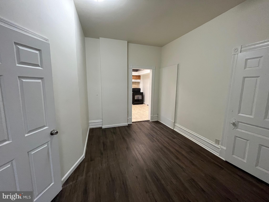 unfurnished bedroom featuring dark wood-type flooring and baseboards