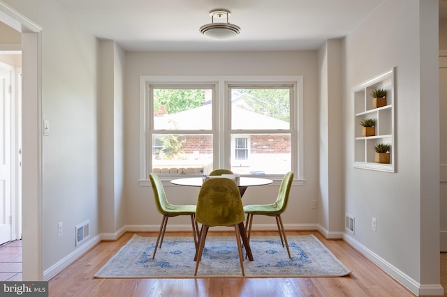 dining area featuring light wood-style floors and baseboards