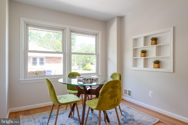 dining space featuring healthy amount of natural light, wood finished floors, and baseboards