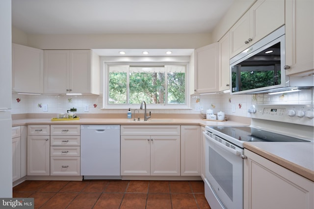 kitchen with white appliances, a sink, white cabinetry, decorative backsplash, and recessed lighting