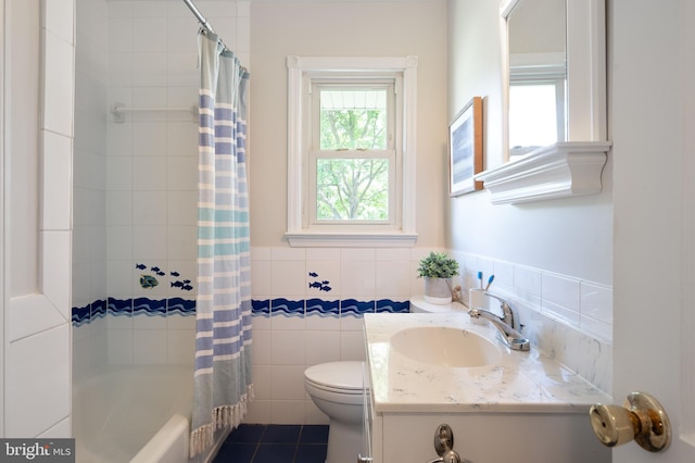 full bath with toilet, tile walls, vanity, shower / tub combo, and wainscoting