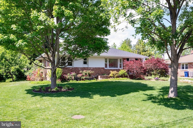 ranch-style home featuring brick siding and a front yard