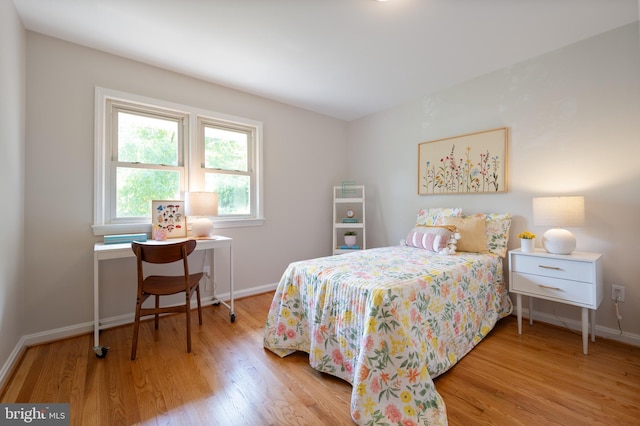 bedroom with wood finished floors and baseboards