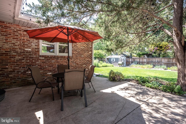 view of patio / terrace featuring a storage unit, an outbuilding, and outdoor dining space
