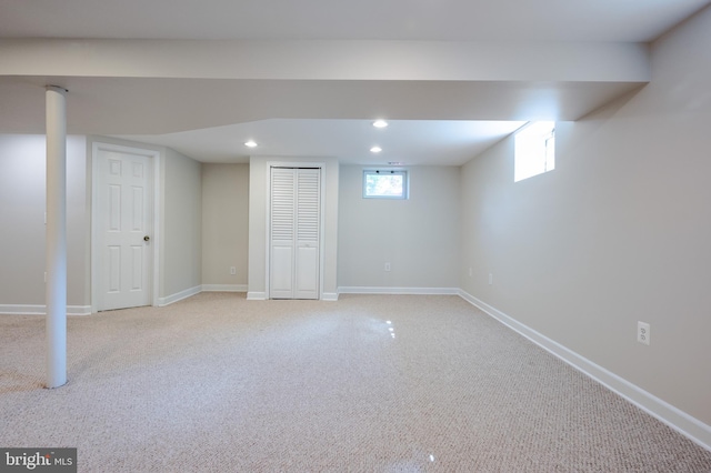 below grade area featuring recessed lighting, light carpet, and baseboards