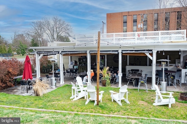 back of property with a patio area and a lawn