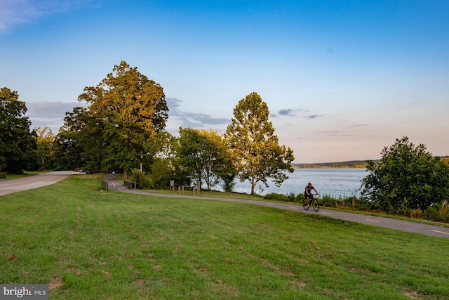 view of property's community featuring a lawn and a water view
