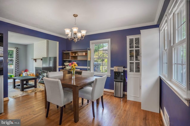 7039 Calamo St, Springfield, VA 22150 - dining space with a chandelier, wood finished floors, crown molding, and baseboards