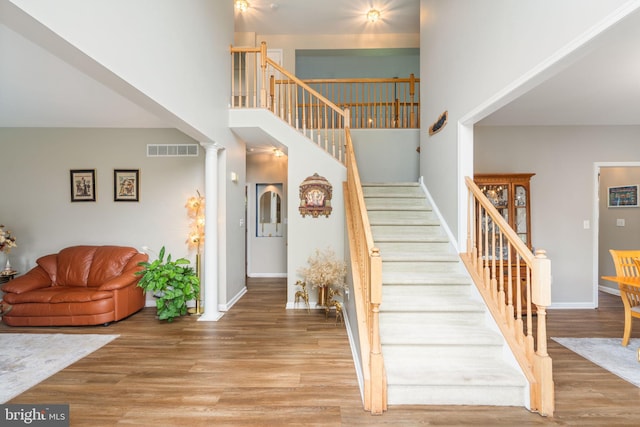27 Avalon Rd, Pennington, NJ 08534 - stairs featuring wood finished floors, a high ceiling, baseboards, and decorative columns
