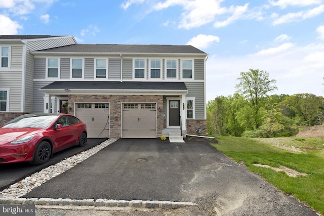 multi unit property with a garage, driveway, and entry steps