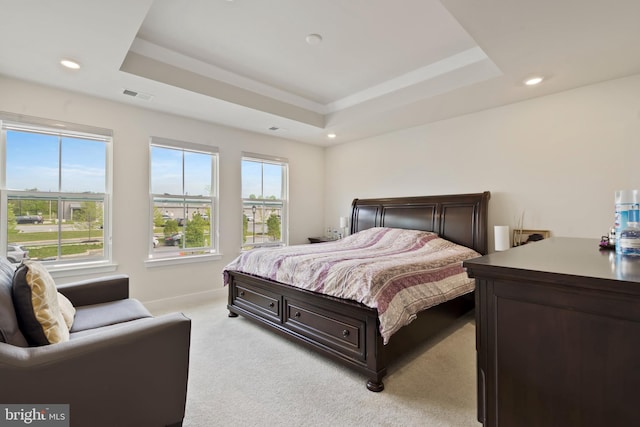 bedroom featuring a tray ceiling, light carpet, recessed lighting, and baseboards