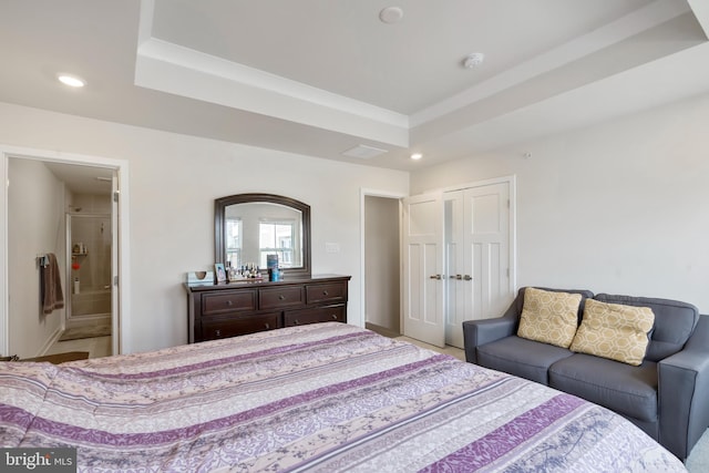 bedroom featuring recessed lighting, a raised ceiling, a closet, and ensuite bathroom