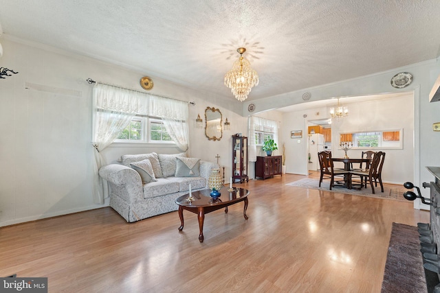 1517 Margaret St, Woodbridge, VA 22191 - living area with a chandelier, crown molding, wood finished floors, a textured ceiling, and arched walkways