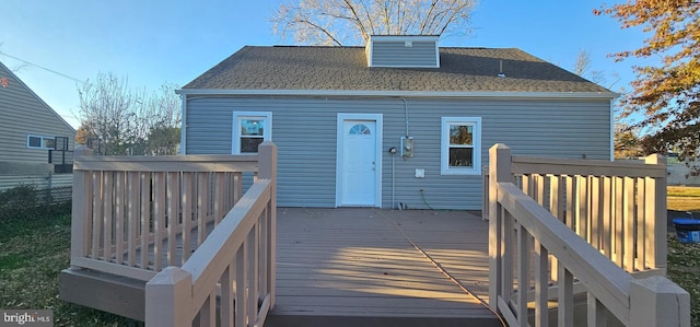 back of house featuring a deck and roof with shingles