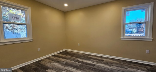 spare room with baseboards, healthy amount of natural light, dark wood-style flooring, and recessed lighting