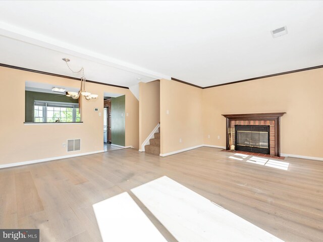 unfurnished living room featuring light wood-style flooring, stairway, a fireplace with flush hearth, a chandelier, and baseboards