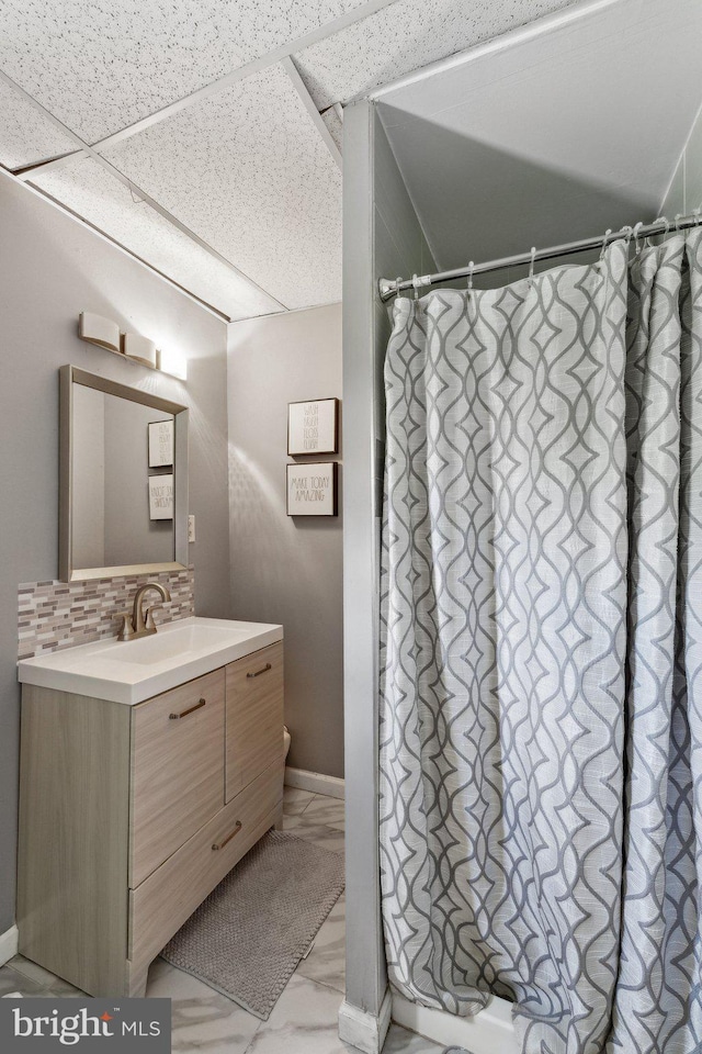 12906 7th St, Bowie, MD 20720 - full bath with marble look tile flooring, vanity, backsplash, and a shower with shower curtain