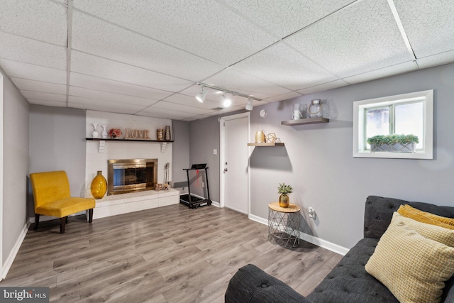 12906 7th St, Bowie, MD 20720 - sitting room featuring wood finished floors, baseboards, a paneled ceiling, a fireplace, and track lighting