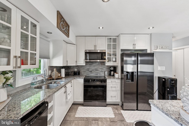 12906 7th St, Bowie, MD 20720 - kitchen with stainless steel appliances, a sink, white cabinetry, decorative backsplash, and light stone countertops