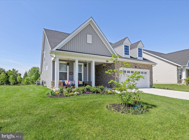 view of front of home with board and batten siding, a porch, concrete driveway, a front lawn, and stone siding