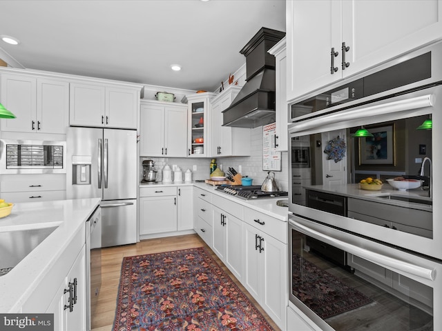 kitchen with stainless steel appliances, light countertops, white cabinets, and recessed lighting