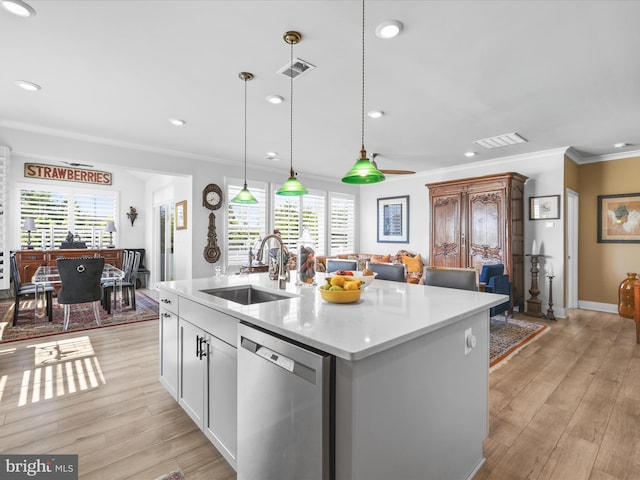 kitchen featuring stainless steel dishwasher, a sink, ornamental molding, light countertops, and light wood-style floors