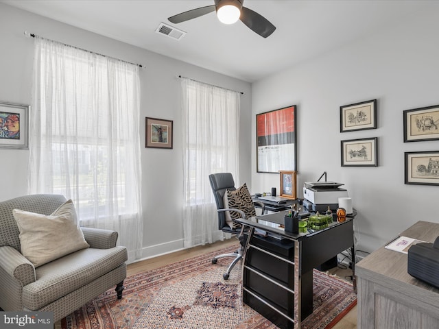 office space featuring a ceiling fan, wood finished floors, and baseboards
