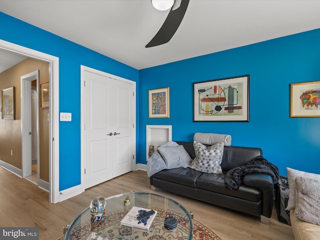living room featuring wood finished floors, ceiling fan, and baseboards