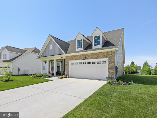 craftsman-style home featuring stone siding, a front lawn, a garage, and driveway