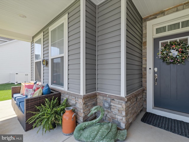 property entrance featuring a porch and stone siding