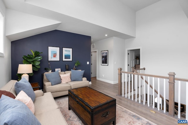living room with wood finished floors, baseboards, and recessed lighting